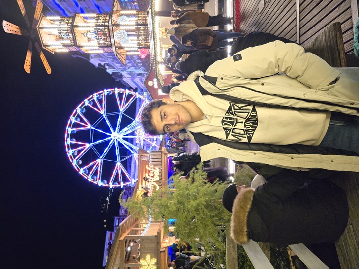 Fiatal ösztöndíjas áll egy vidámpark előtt