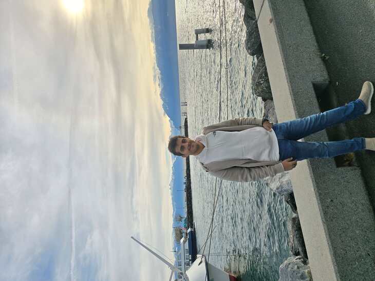 Fiatal ösztöndíjas áll egy hajókikötő előtt